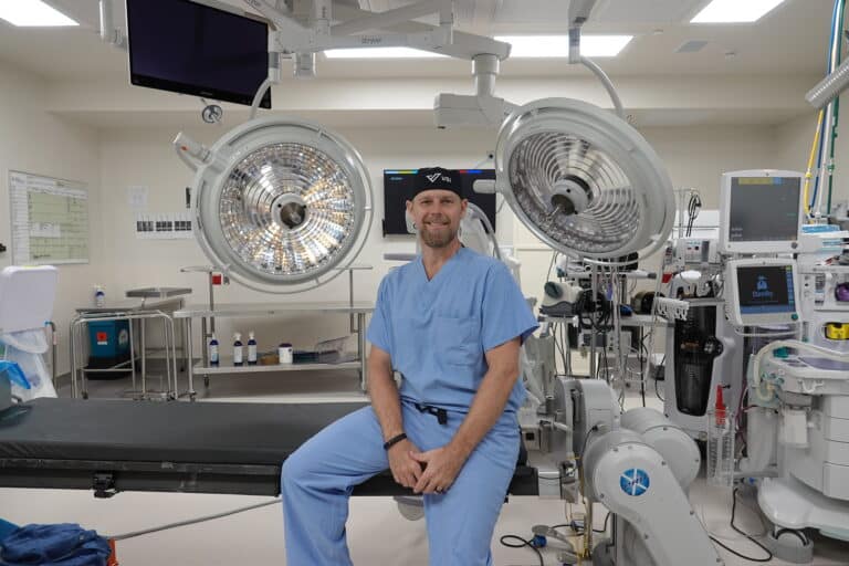 dr. good leaning against operating room table