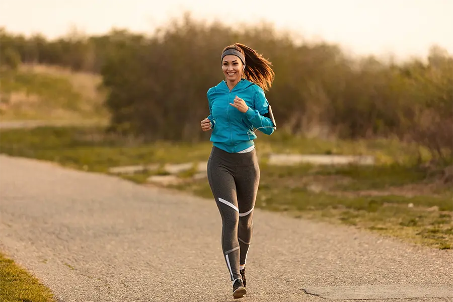 happy female runner jogging on the road