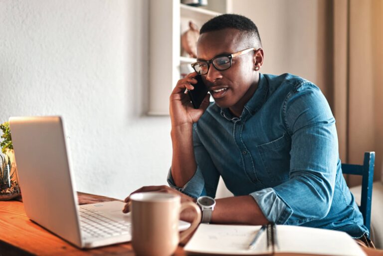 Man on his laptop talking to someone on the phone