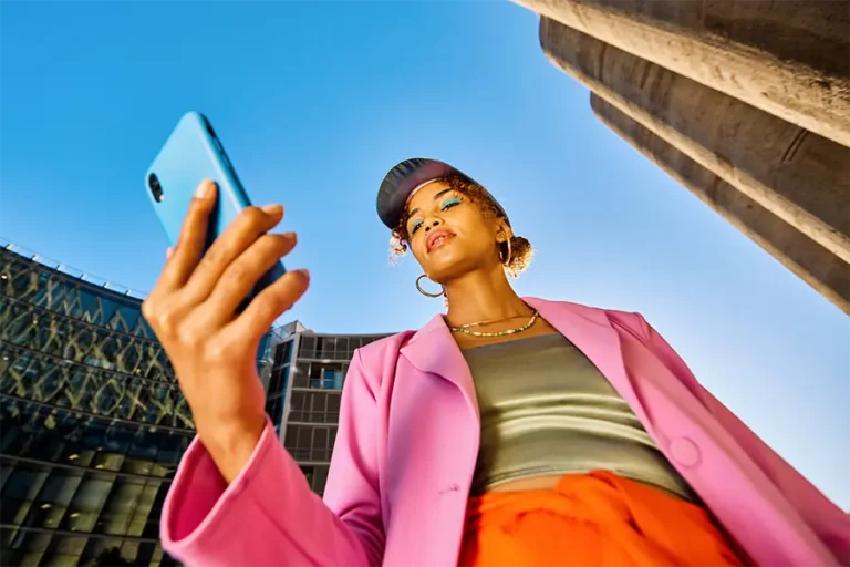 girl in pink looking down at new trend on phone