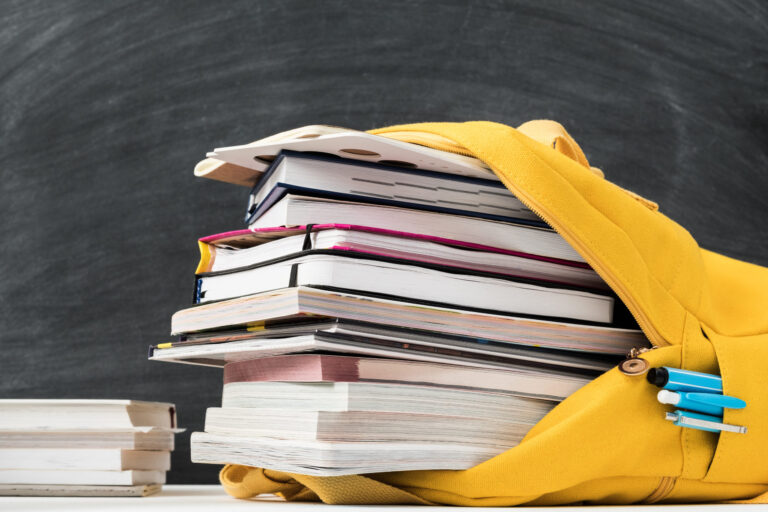 pile of books stacked in a backpack