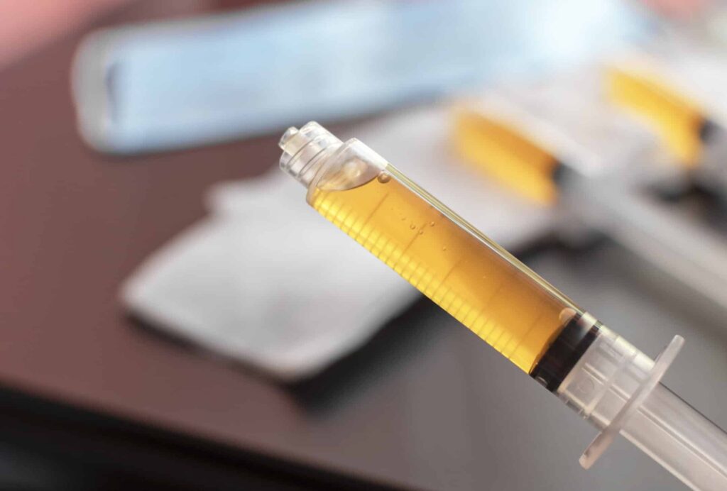 blood plasma in a syringe on a blurred background. blood plasma as a solution for the treatment of coronavirus.