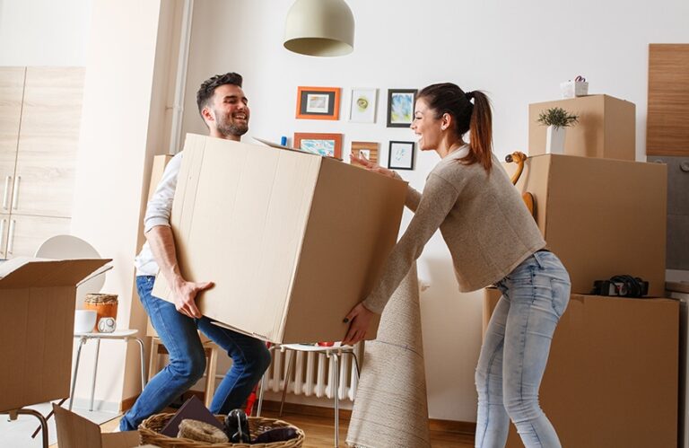 A couple lifting a heavy box together