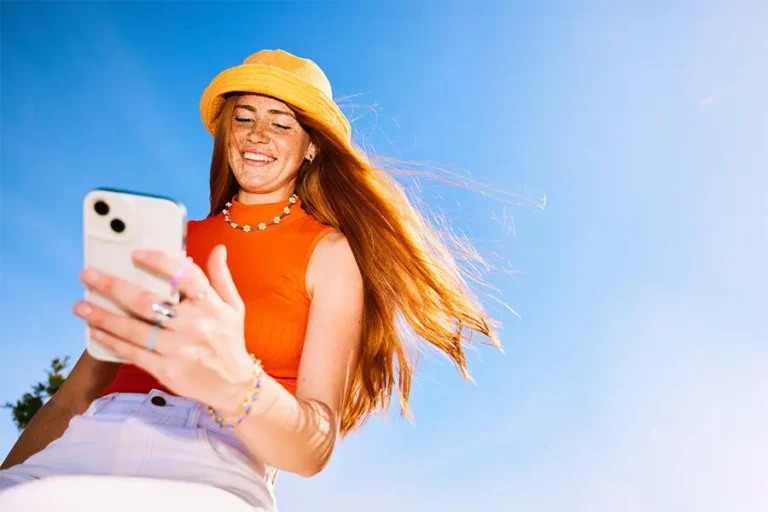 cheerful young woman walking and looking at tiktok trend