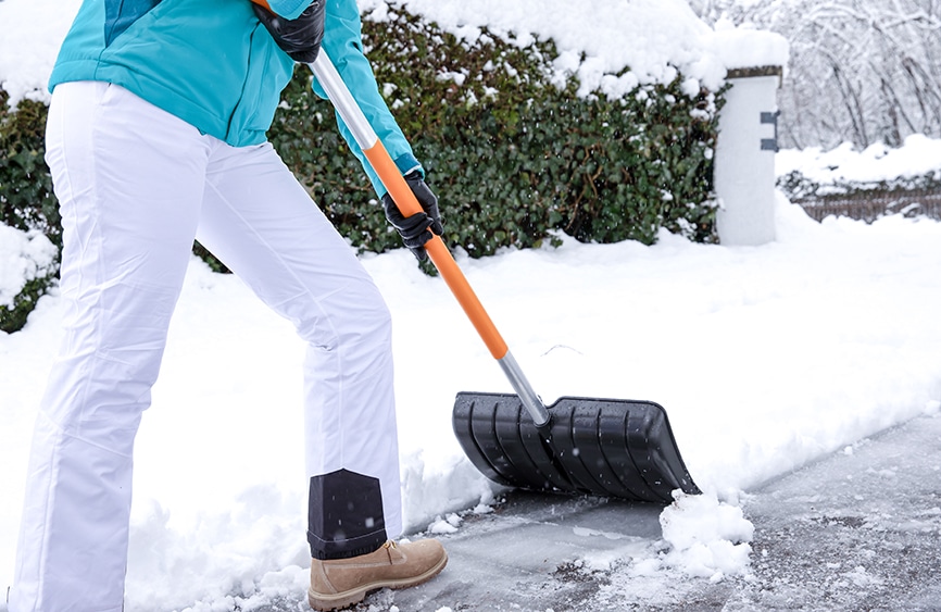 woman shoveling snow waist-down