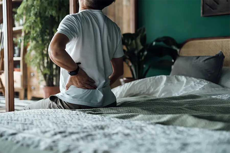 rear view of asian man suffering from lower back pain