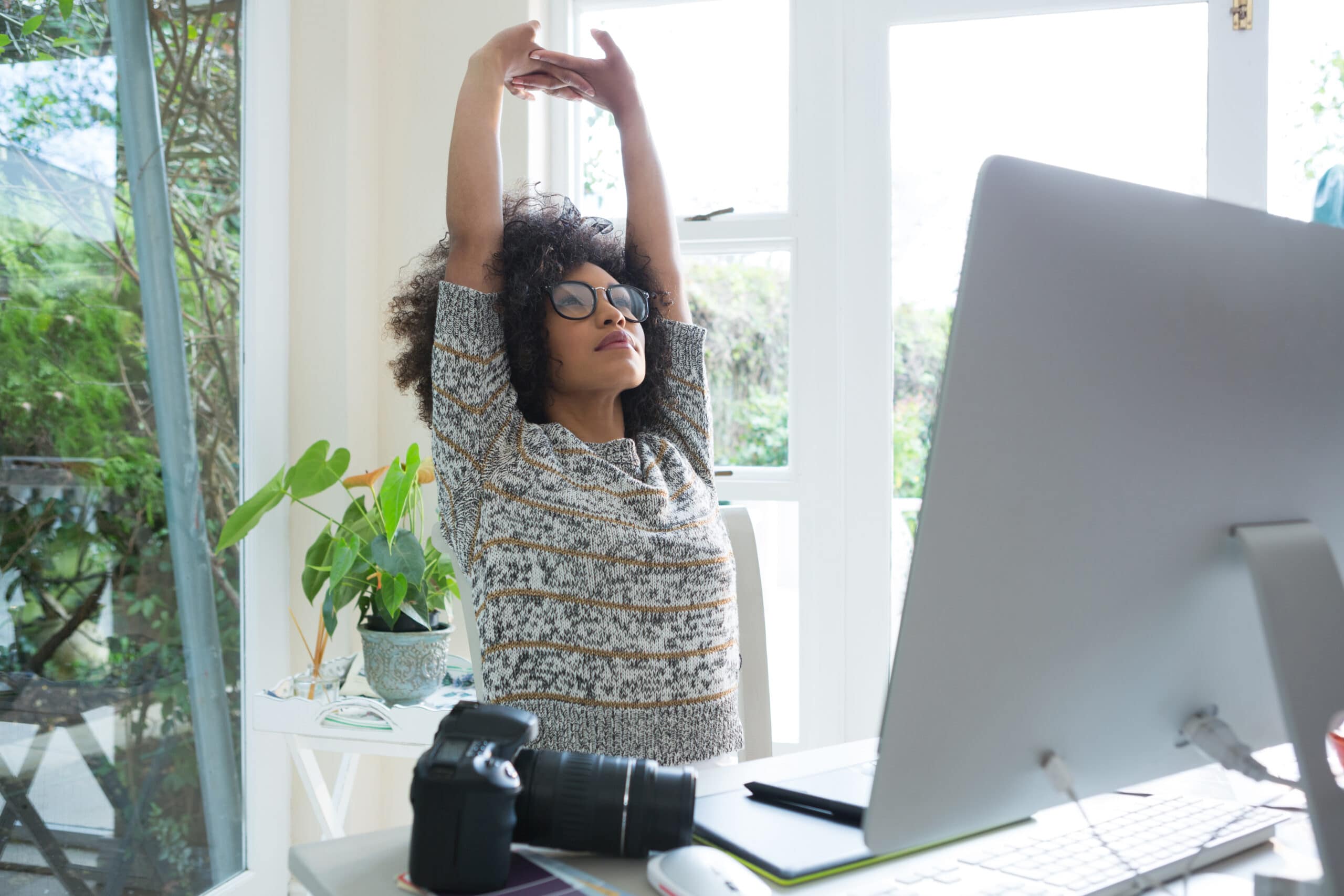 A woman stretching in front of a computer