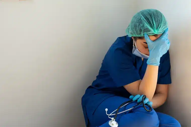 tired healthcare worker sitting on the floor