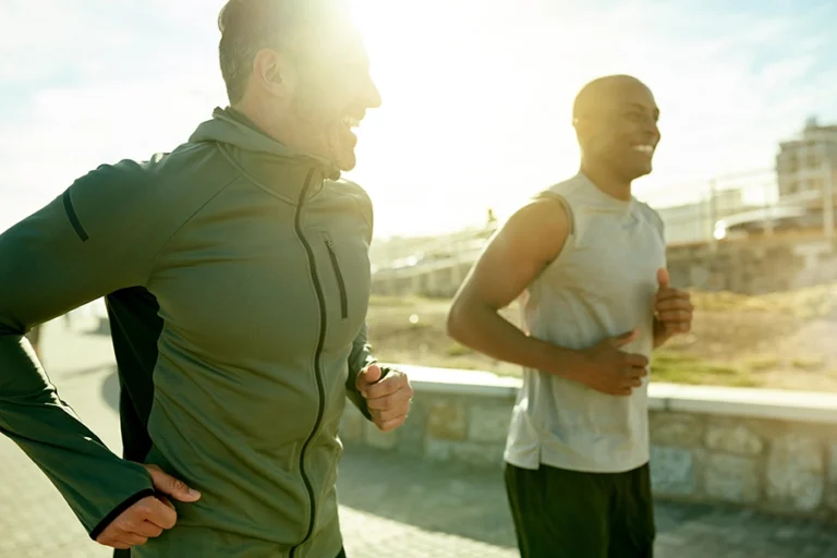 two men running with the bright sun