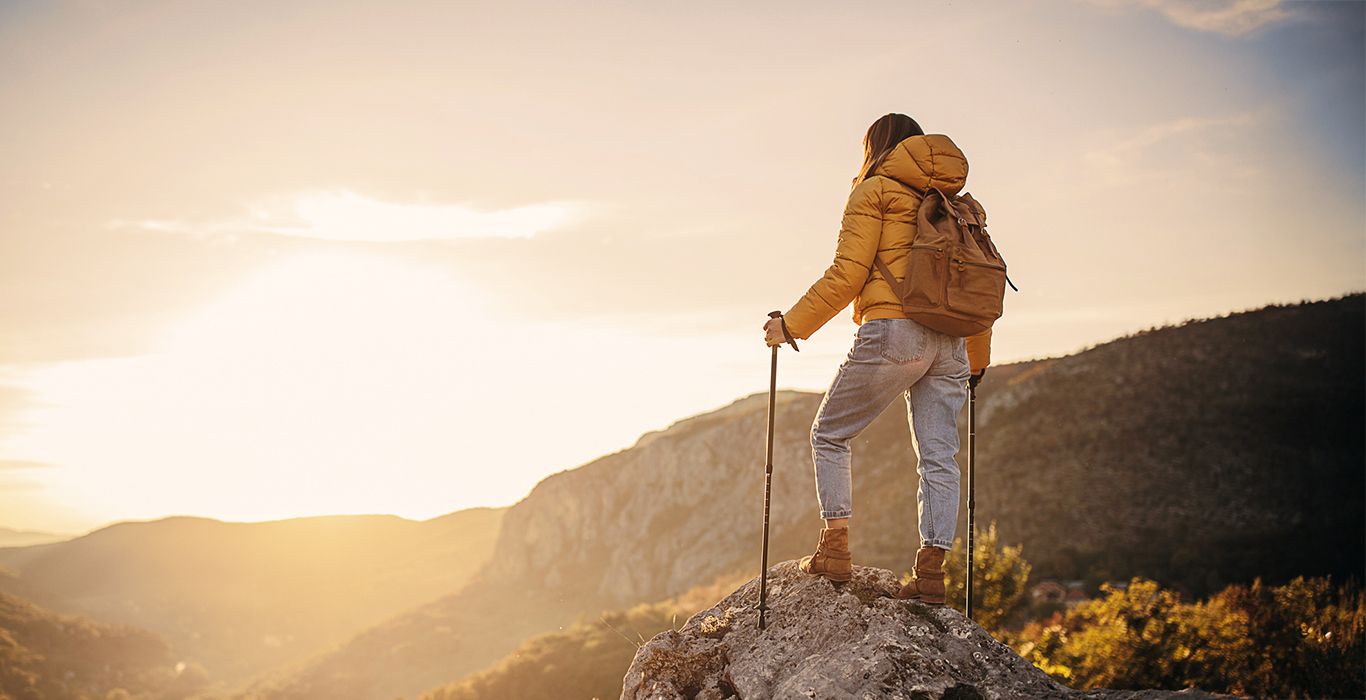 young woman hiker overcoming back pain